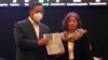 El presidente de Bolivia, Luis Arce, muestra el informe de expertos de la CIDH sobre los sucesos de 2019 junto a la representante del grupo, Patricia Tappata, en La Paz, Bolivia el 17 de agosto de 2021. 