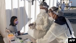 Wafanyakazi wa afya wakivalia vifaa vya kujilinda na maambukizi ya COVID-19 (PPE) wakijitayarisha kumpima mwanamke iwapo ana maambukizi ya COVID-19 katika hospitali ya Fourways Life Johannesburg, Juni 28, 2021. Photo by Emmanuel Croset / AFP)