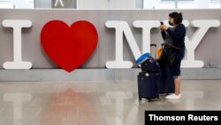 A traveler uses her phone at LaGuardia Airport, during the outbreak of the coronavirus disease (COVID-19), in New York