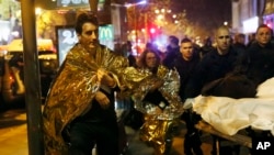 Victims walk away outside the Bataclan theater in Paris, Nov. 13, 2015. The attacks killed 130 people.