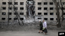 Starice hodaju pored hostela uništenog tokom ruskog bombardovanja grada Seljdove u regionu Donjeck, 14. aprila 2024. godine. (Foto: AFP/Anatolii Stepanov)