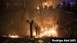 Protesters burn a subway station in Santiago, Chile, Monday, Oct. 28, 2019.