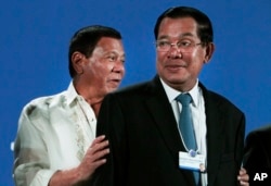 FILE-Philippine President Rodrigo Duterte, left, and Cambodian Prime Minister Hun Sen, right, attend an opening the World Economic Forum on ASEAN, in Phnom Penh, Cambodia, Thursday, May 11, 2017.