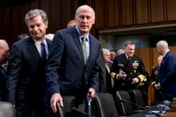 FILE - FBI Director Christopher Wray, left, and Director of National Intelligence Dan Coats, second from left, arrive for a hearing in Washington, Feb. 13, 2018.