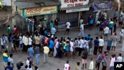 Indians line up without maintaining physical distance to buy liquor outside one of the liquor shops which reopened Monday after six weeks lockdown on the outskirts of Mumbai, India, May 4, 2020. 