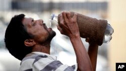 An Indian drinks water from a bottle on a hot summer day in Allahabad, India, Sunday, May 31, 2015.