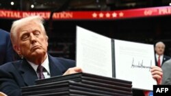 Predsjednik SAD-a Donald Trump drži jednu od izvršnih uredbi koju je potpisao tijekom inauguracijske parade u Capital One Areni, u Washingtonu. (Foto: Jim WATSON/AFP)