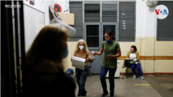 Trabajadores electorales esperan el cierre de la mesa electoral durante las elecciones en Venezuela.