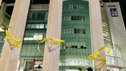 有市民在蘋果日報大樓外的鐵欄上綁上象徵自由的黃絲帶。 (美國之音湯惠芸)