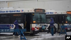 Autobuses de la Autoridad de Tránsito de Chicago, acondicionados para que los migrantes se puedan calentar durante una tormenta invernal, están estacionados en la cuadra 800 de la calle South Desplaines, viernes 12 de enero.