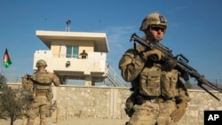 A U.S. soldier from Dragon Company of the 3rd Cavalry Regiment stands in front of an Afghan National Army guard post during a mission near forward operating base Gamberi in the Laghman province of Afghanistan December 28, 2014.
