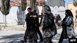 Relatives of the victims arrives at the site following gunmen shot dead two Afghan women judges working for the Supreme Court, in Kabul on January 17, 2021. - Gunmen shot dead two Afghan women judges working for the Supreme Court during an early…