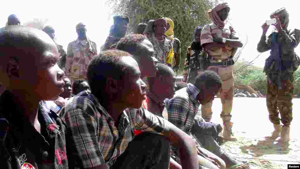 Tsoiffin 'yan kungiyar Boko Haram sun tattaru a gaban sojojin Chadi a garin Ngouboua ran 22 Afrilu, 2015. Yaran sun ce su 'yan kasar Chadi ne wadanda aka tilasta musu shiga kungiyar Boko Haram lokacin da suke karatun allo a Najeriya, amma daga baya sun kubuce suka gudu, suka mika kawunansu ga sojojin Chadi.