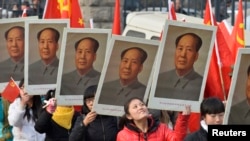 中国山西省太原一所大学的学生手举中共前领导人毛泽东的画像庆祝毛泽东诞辰120周年。（2013年12月21日）