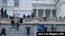 ARHIVA - Pristalice bivšeg predsednika Donalda Trampa penju se uz zapadni zid američkog Kapitola, 6. januara 2021.