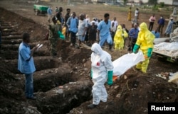 Health workers carry the body of an Ebola victim for burial at a cemetery in Freetown, December 17, 2014. The death toll in the Ebola epidemic has risen to 6,915 out of 18,603 cases as of Dec. 14, the World Health Organization (WHO) said on Wednesday. Th