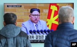 People watch a TV screen showing North Korean leader Kim Jong Un's New Year's speech, at Seoul Railway Station in Seoul, South Korea, Jan. 3, 2018. North and South Korea agreed Friday to revive their formal dialogue.