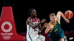 El estadounidense Jrue Holiday (12) y el australiano Jock Landale (13) persiguen el balón durante el juego de semifinales de baloncesto masculino en los Juegos Olímpicos de Verano de 2020, el jueves 5 de agosto de 2021 en Saitama, Japón. (Foto AP / Eric G