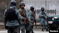 FILE - Afghan policemen stand at the site of a suicide attack in Kabul, February 26, 2015.