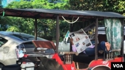 ពលរដ្ឋ​កម្ពុជាម្នាក់កំពុងអានកាសែត រាជធានីភ្នំពេញ ថ្ងៃទី២៩ ខែសីហា ឆ្នាំ២០១៧។ (ខាន់ សុគុំមនោ/VOA)