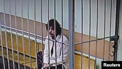 যুক্তরাষ্ট্রের নাগরিক, কেলব ওয়েন বায়ার্সকে ২০২৪ সালের ৭ অক্টোবরে রাশিয়ার মস্কোতে এক আদালতের অধিবেশন চলাকালে খাঁচার মধ্যে বসে রয়েছেন। চলতি বছরের ১৫ ফেব্রুয়ারিতে মস্কো সিটি কোর্ট প্রেস সার্ভিস কর্তৃক প্রকাশিত ভিডিও থেকে ছবিটি নেওয়া হয়েছে।