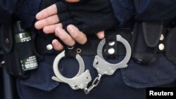 FILE - A Turkish riot police officer's handcuffs are pictured at the entrance of a courthouse in Istanbul. Human Rights Watch is calling for "urgent and effective investigation of the abduction and possible enforced disappearances of at least four men in Ankara since March 2017."