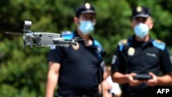 Policijski dron u Kataloniji upozorava ljude da poštuju bezbednosne mere, 14. jul 2020 (Foto: MIGUEL RIOPA / AF)
