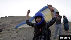 Afghan paraglider Leeda Ozori, 21, prepares to practice, outside Kabul, September 17, 2015.
