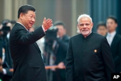 រូប​ឯកសារ៖ ប្រធានាធិបតី​ចិន ស៊ី ជីនពីង ស្វាគមន៍​នាយក​រដ្ឋ​មន្ត្រី​ឥណ្ឌា ​Narendra Modi សម្រាប់​កិច្ច​ប្រជុំ​អង្គការ​សហប្រតិបត្តិការ​ក្រុង​សៀងហៃ នៅ​ក្រុង Qingdao នៃ​ខេត្ត Shandong ភាគ​ខាង​កើត​នៃ​ប្រទេស​ចិន កាល​ពី​ឆ្នាំ​មុន។