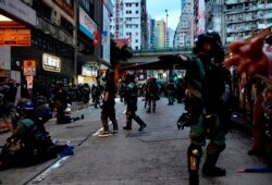 FILE - Riot police tell journalists to leave while they arrest protesters in Hong Kong, Oct. 6, 2019.