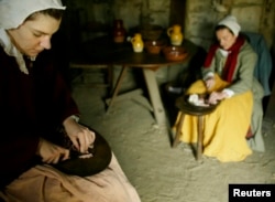FILE – Reactors dressed as Pilgrims prepare a meal at Plimoth Plantation in Plymouth, Massachusetts in this 2004 file photo.