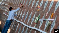 ญาติเหยื่อเหตุการณ์สึนามิปี 2547 ปักดอกไม้ที่แผ่นจารึก ที่อนุสรณ์สถานที่บ้านน้ำเค็ม อ.ตะกั่วป่า จ.พังงา วันที่ 26 ธันวาคม 2567 (ที่มา:AP)