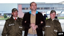 Archivo - En esta foto tomada el 13 de mayo de 2008, el exlíder paramilitar colombiano de las Autodefensas Unidas de Colombia (AUC), Salvatore Mancuso (C) alias Santander Lozada, es escoltado por policías antes de ser extraditado a EE.UU.