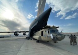 Sur cette image fournie par le ministère américain de la Défense, un avion CH-47 Chinook de la 82e division aéroportée est chargé sur un C-17 Globemaster III de l'armée de l'air américaine à l'aéroport international Hamid Karzai de Kaboul, en Afghanistan, le samedi 28 août 2021.