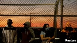 Migrantes en la cola del programa "Permanecer en México" en el puente fronterizo Paso del Norte para reprogramar sus audiencias de inmigración en medio del brote de la enfermedad del coronavirus (COVID-19), en Ciudad Juárez, México, 21 de abril de 2020