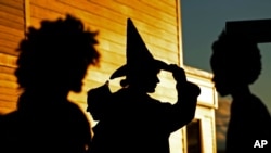 FILE - Parents wait as their children trick-or-treat at a shopping center in Freeport, Maine, Oct. 31, 2017.