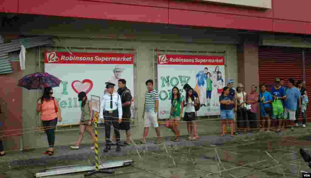 A few large stores have reopened in Ormoc have long lines of customers desperate for items in short supply, Philippines, Nov. 17, 2013. (Steve Herman/VOA)