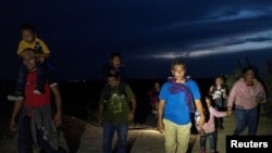 Familias de migrantes solicitantes de asilo de Guatemala y Honduras caminan hacia la carretera principal después de cruzar el río Grande hacia los Estados Unidos desde México en Roma, Texas, EE. UU., 28 de julio de 2021.