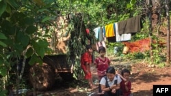 FILE - This picture taken on June 3, 2021 shows people taking refuge in a jungle area in Demoso, Kayah state. (Photo by STR / AFP)