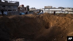 Palestinianos inspeccionam os danos causados pelos ataques aéreos israelitas durante a noite na Cidade de Gaza, sexta-feira, 7 de abril de 2023.