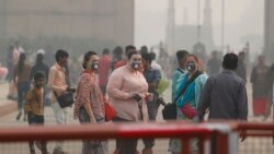 Indian and foreign tourists wear pollution mask and take a walk at the India Gate amidst morning smog in New Delhi, India, Monday, Nov. 4, 2019. (AP Photo/Manish Swarup)