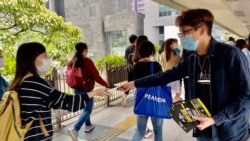 香港民間人權陣線召集人陳皓桓派傳單，呼籲市民關注入境條例修訂 (美國之音湯惠芸)