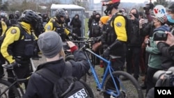 Manifestantes rodean a un grupo de policías durante las protestas en Portland, Oregón, el miércoles 20 de enero de 2021.