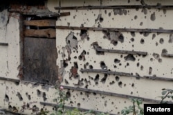 The wall of a house covered in shrapnel scars is seen in Oktyabrsky district of Donetsk, Ukraine, Oct. 25, 2017.