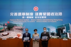 香港特首林郑月娥（中）在香港举行的相关中国人大通过香港选举新规的记者会上。（2021年3月30日）