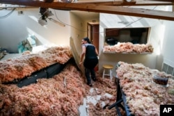 Erica Bohannon leads reporters through her destroyed apartment, May 28, 2019, in Trotwood, Ohio, after a tornado storm system passed through the area the night before, tearing her roof off while she huddled with her son and dog in her bedroom closet.