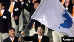 North Korea's Jang Choo Pak (L) and South Korea's Eun-Soon Chung carry a flag bearing the unification symbol of the Korean peninsula during the opening ceremony of the Sydney 2000 Olympic Games.