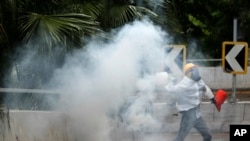 Un manifestante envía de vuelta a la policía una lata de gas lacrimógeno en Hong Kong, el domingo 6 de octubre de 2019. (AP Foto/Vincent Thian)