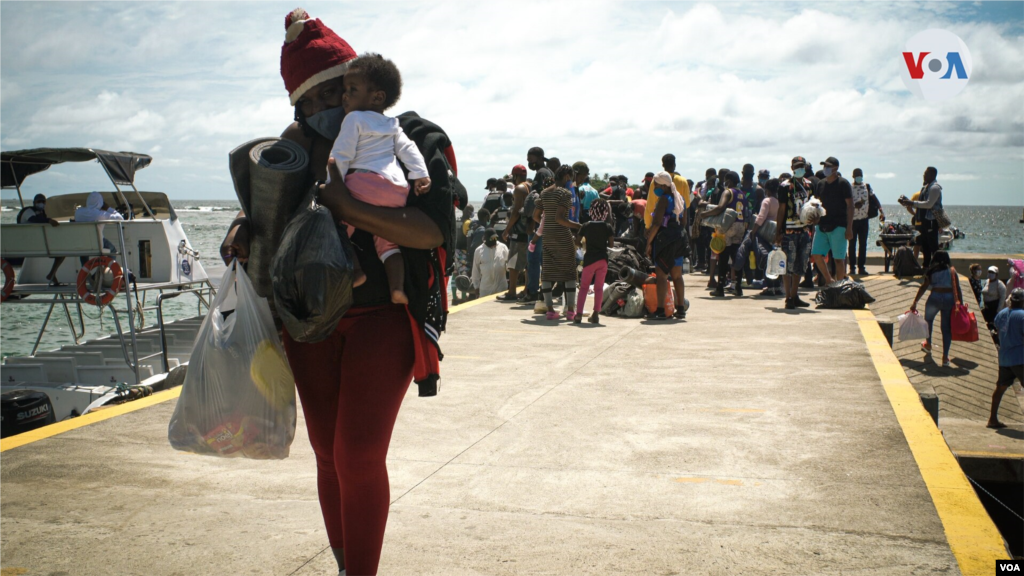 Equipados con tiendas de campaña, colchonetas, plásticos para la lluvia, entre otros enseres, los migrantes arriban al muelle de Capurganá en la frontera con Panamá.