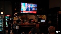 El ministro de Economía de Argentina, Luis Caputo, es visto en la televisión durante un anuncio de las nuevas medidas económicas del gobierno del presidente Javier Milei, en Buenos Aires, el 12 de diciembre de 2023.